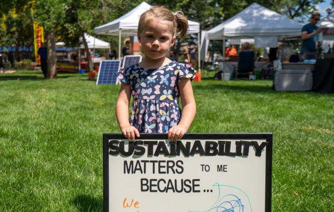 little girl with a sign that says why sustainability matters to her